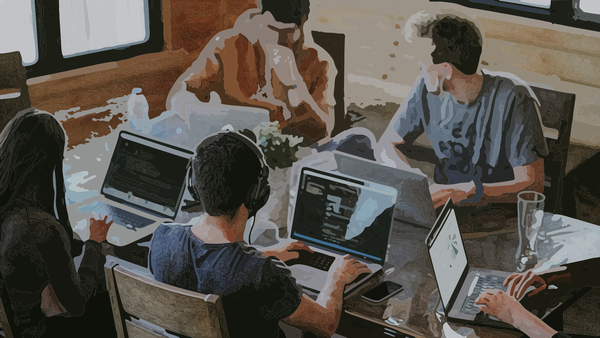 A group of people in their 20s or 30s working on laptops around a table.